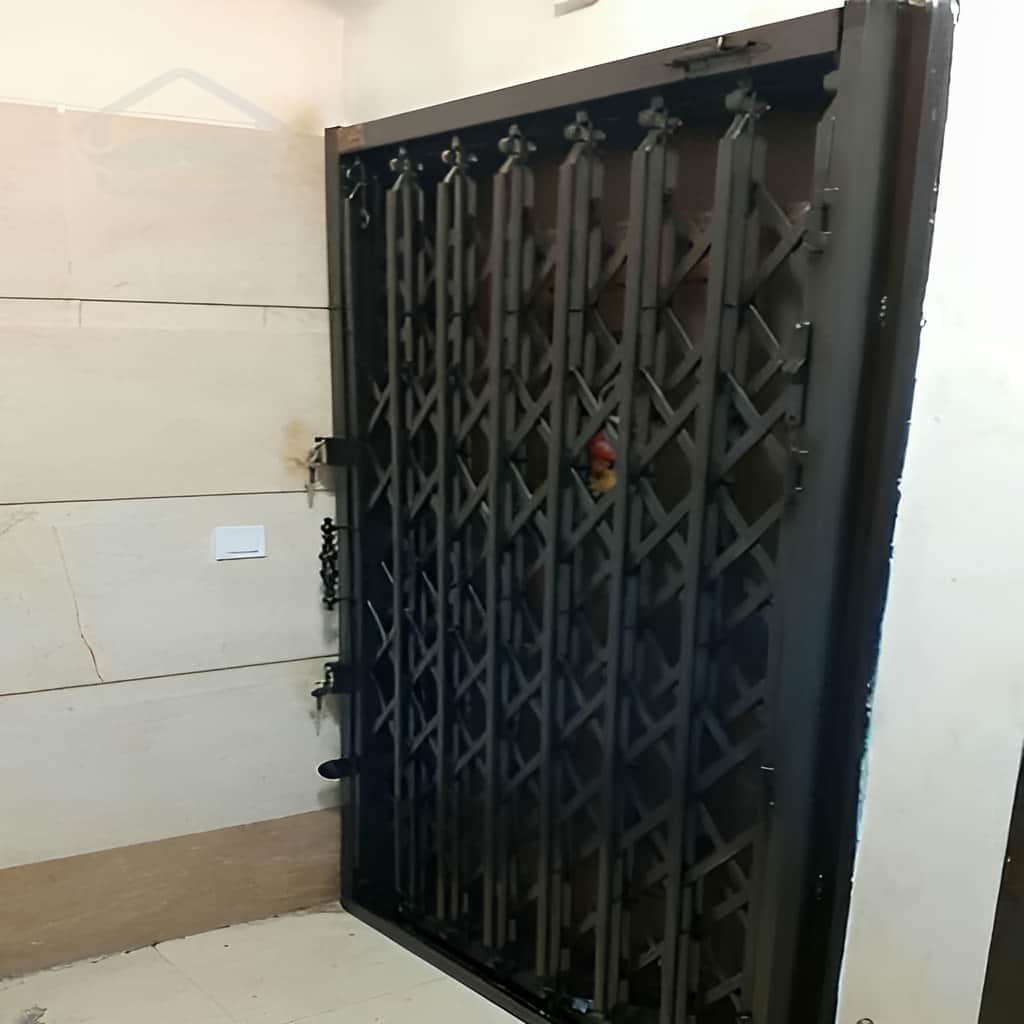 اجرای درب آکاردئونی تسمه پهن آهنی با ریل روان