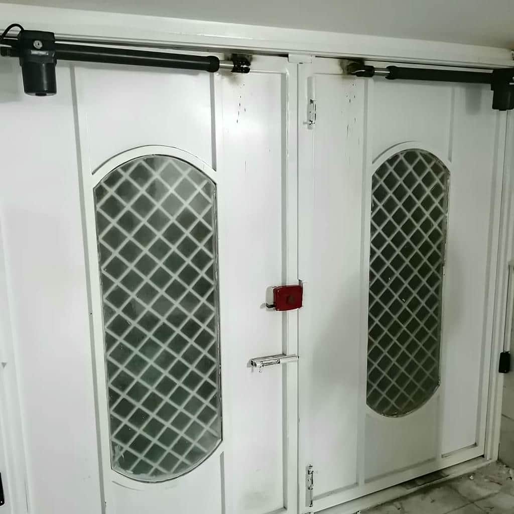 درب پارکینگ بازویی جک دار روی درب فلزی مشکی